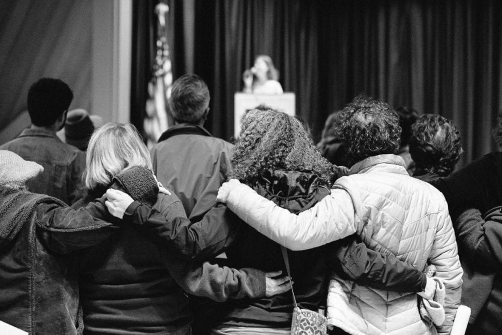 Black and white photo of the backs of women embracing