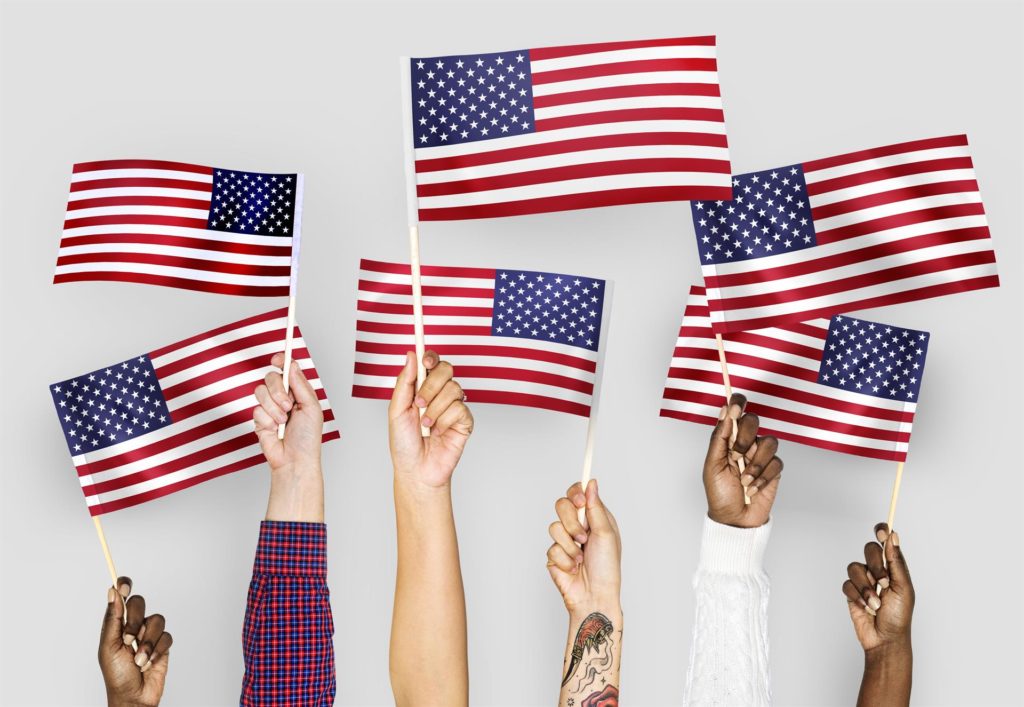 Hands holding the American flag in the air