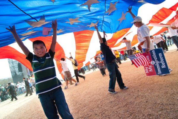 Young boy helping to hold a large American flag