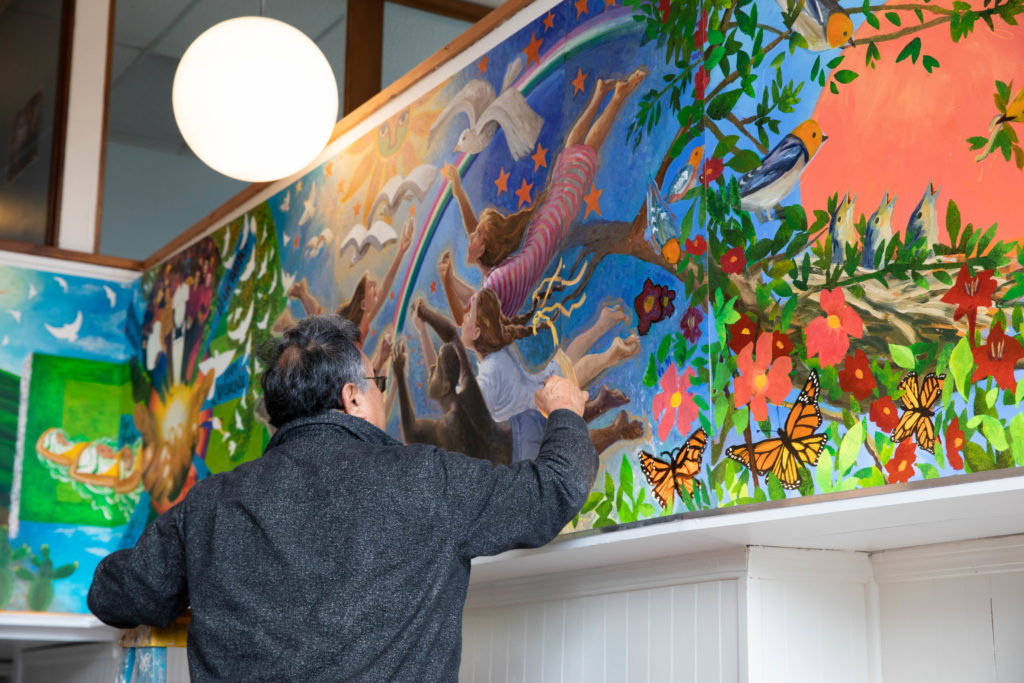 Artists, Guillermo Kelly, adding the finishing touches to his mural contribution.