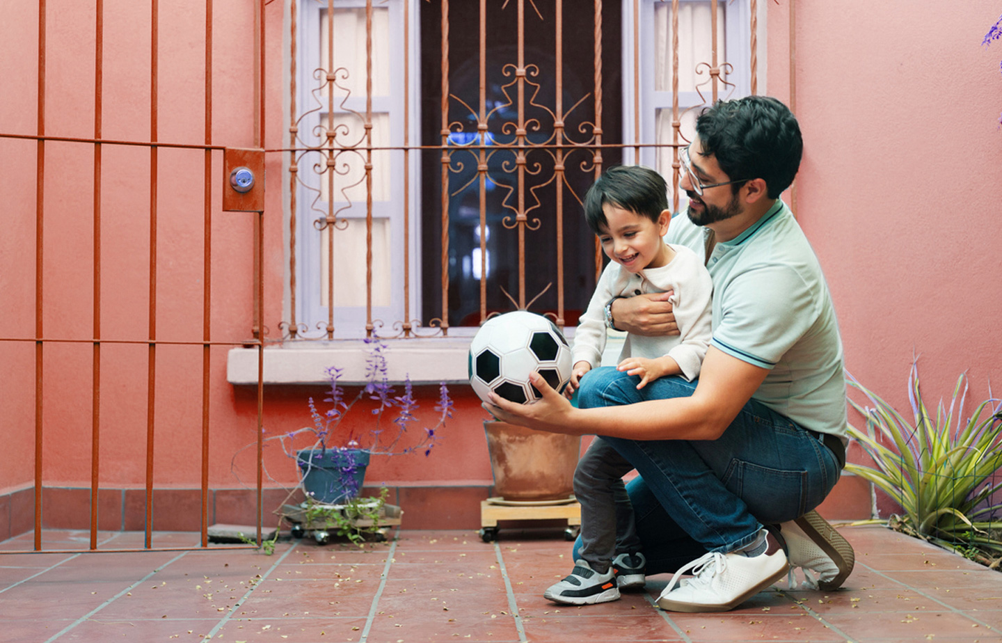 Man with a kid playing with soccer ball