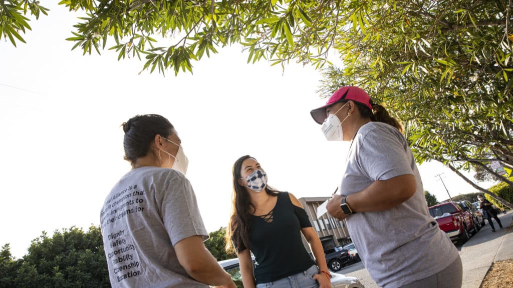 Canal Alliance staff and community member talking in the neighborhood.